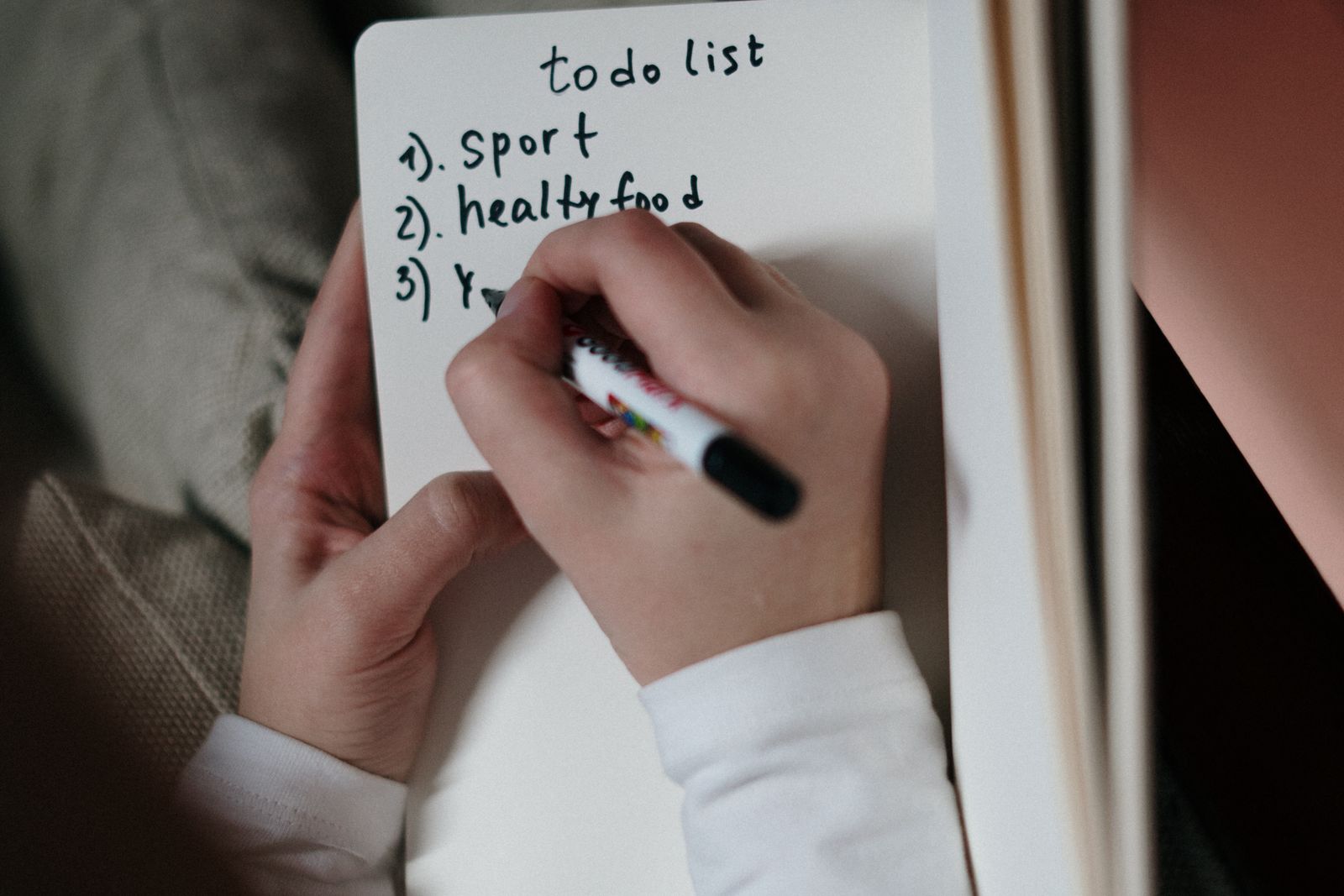Manos escribiendo una lista de pendientes, un brain dump para vaciar la cabeza