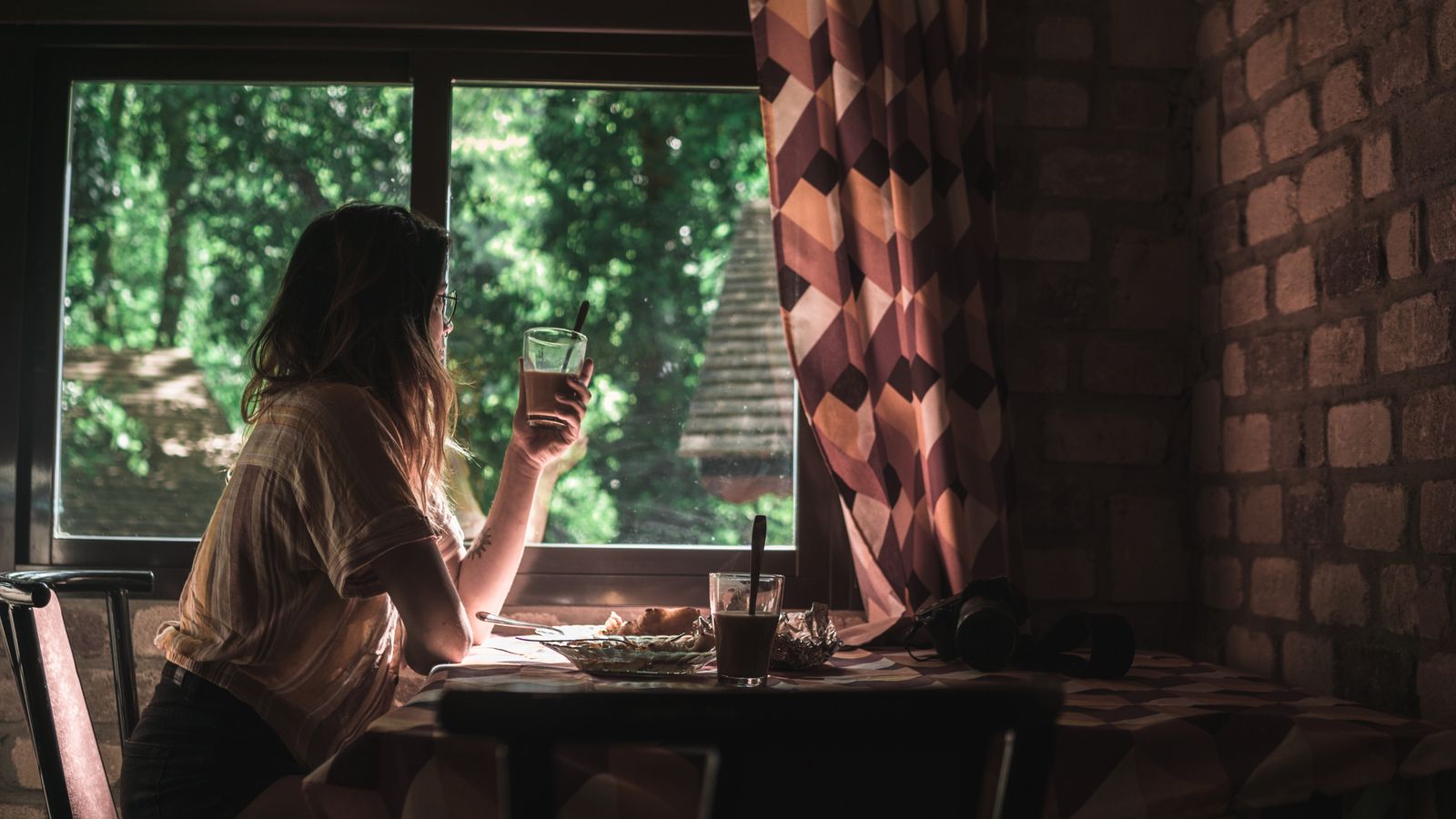Mujer en calma junto a la ventana con una taza, atravesando el duelo de un diagnóstico tardío de TDAH