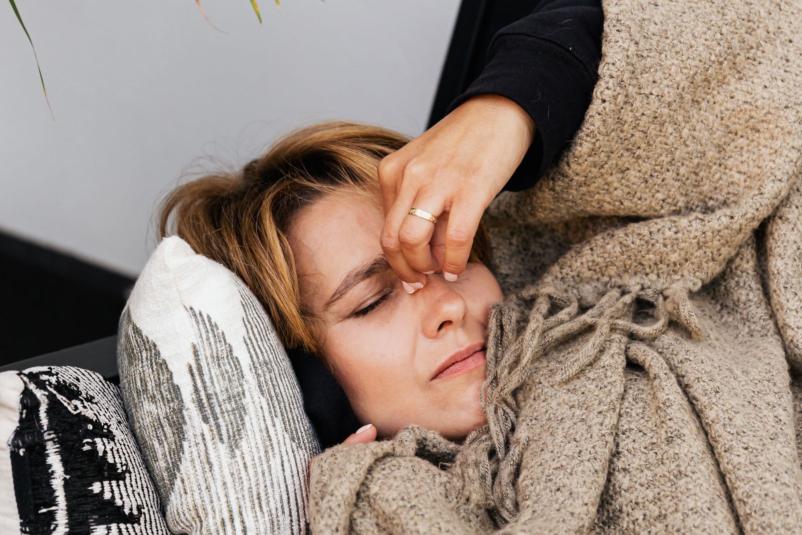 Mujer recostada con dolor de cabeza, un día en que el TDAH y las hormonas se combinan