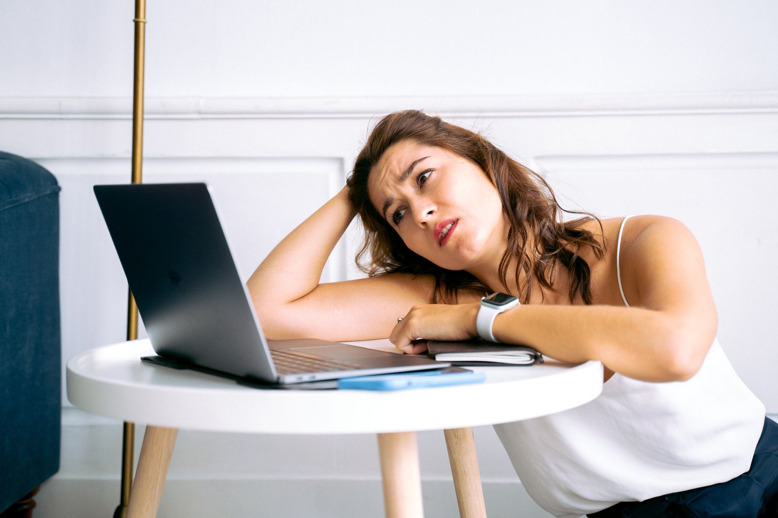 Woman stuck in ADHD task paralysis, staring at her laptop unable to start