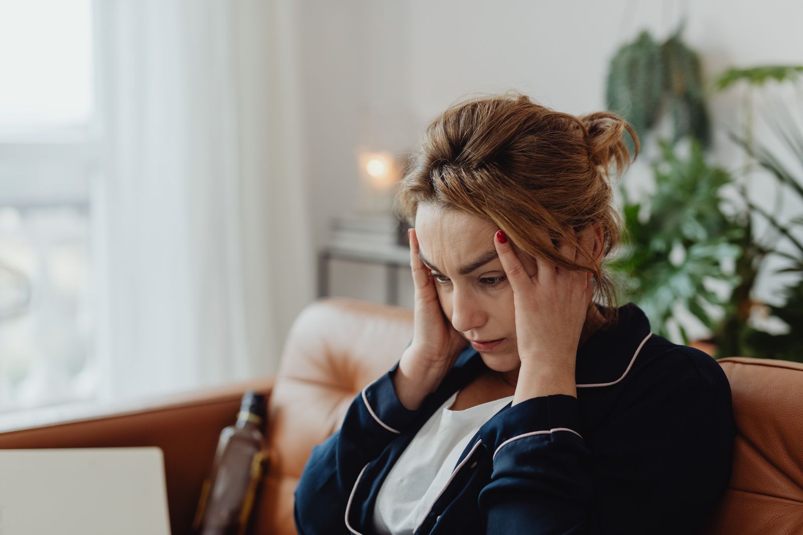 Overwhelmed woman at home holding her head, the ADHD overwhelm shutdown moment