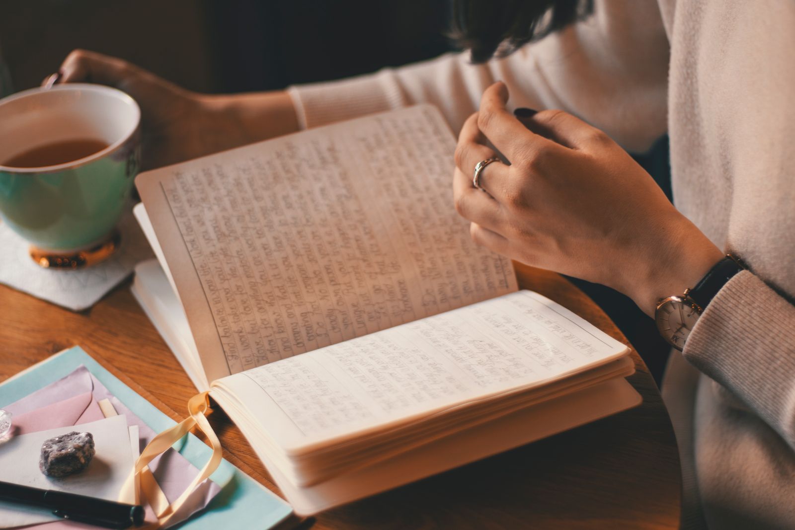 Woman doing a brain dump in a notebook with tea, emptying an overloaded ADHD mind onto paper