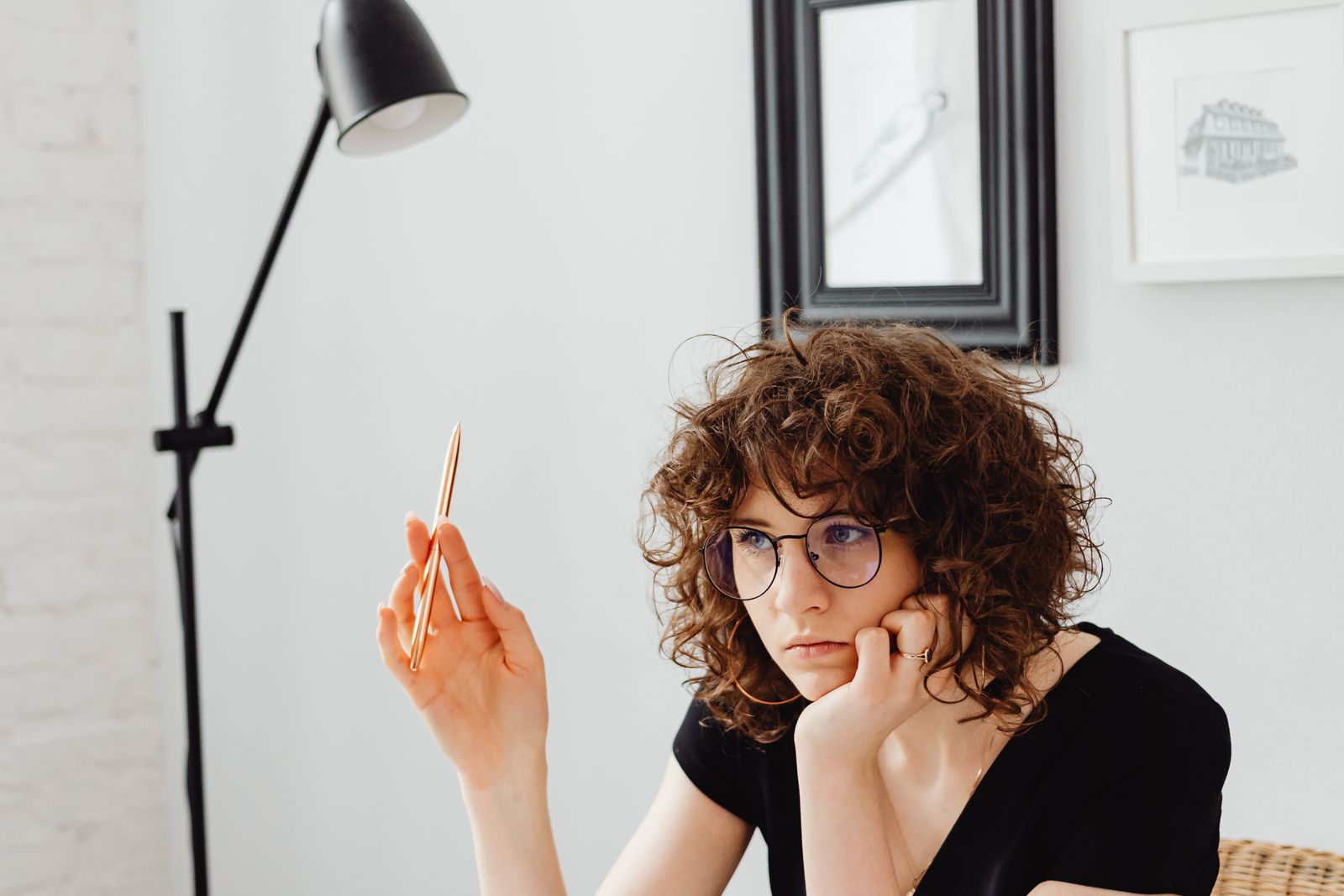 Woman with a pen staring past her desk, the executive dysfunction gap between knowing and doing
