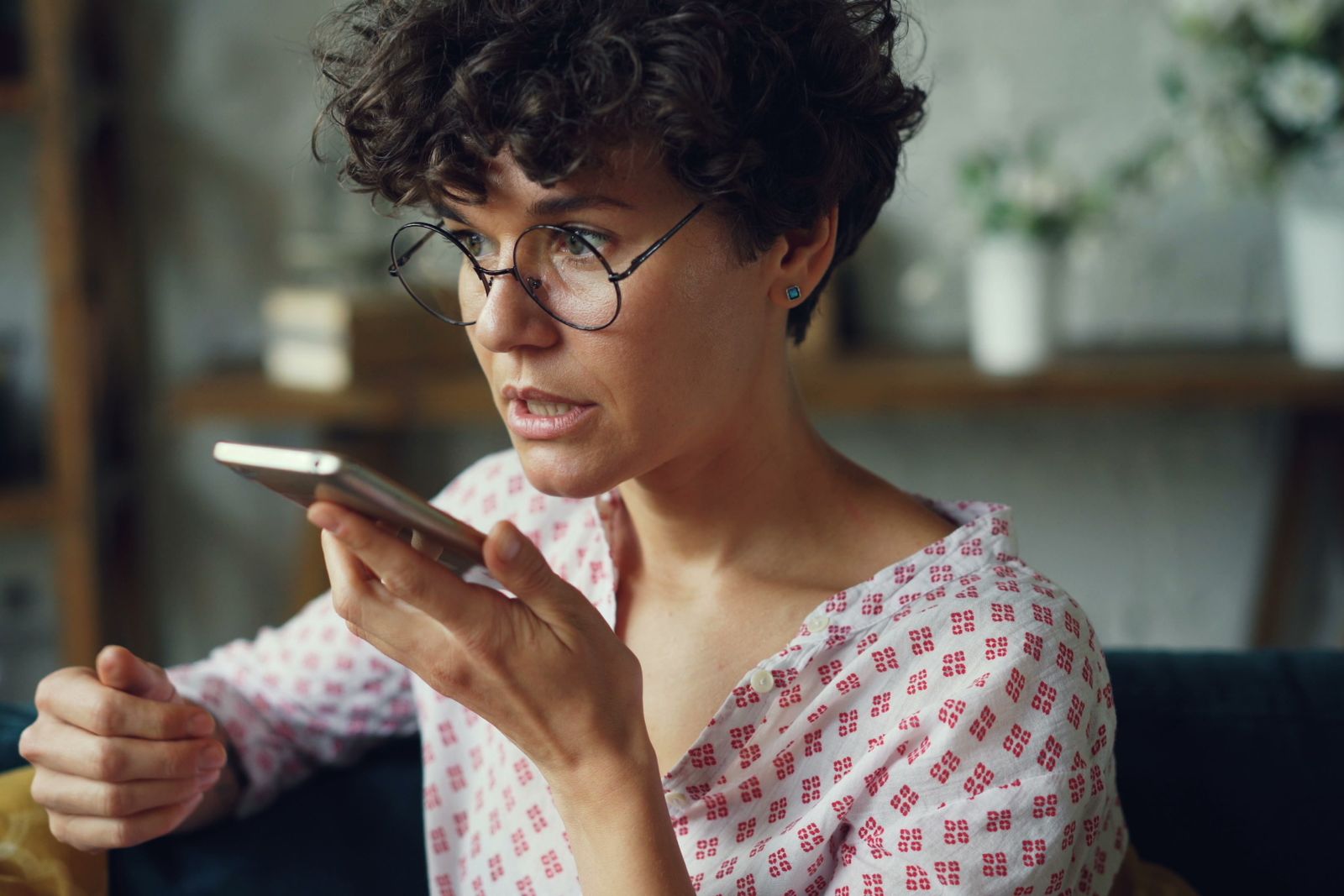 Woman with ADHD recording a voice note on her phone at home